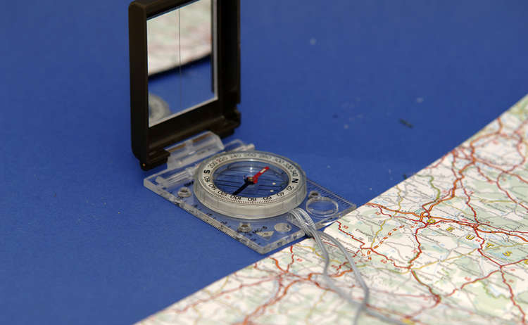 4) Deshalb benötigt der Kompass ein eckiges Gehäuse: Dieses wird an die Außenkante der Karte gelegt und beides so lange gedreht, bis Kompass- und Karten-Norden übereinstimmen.